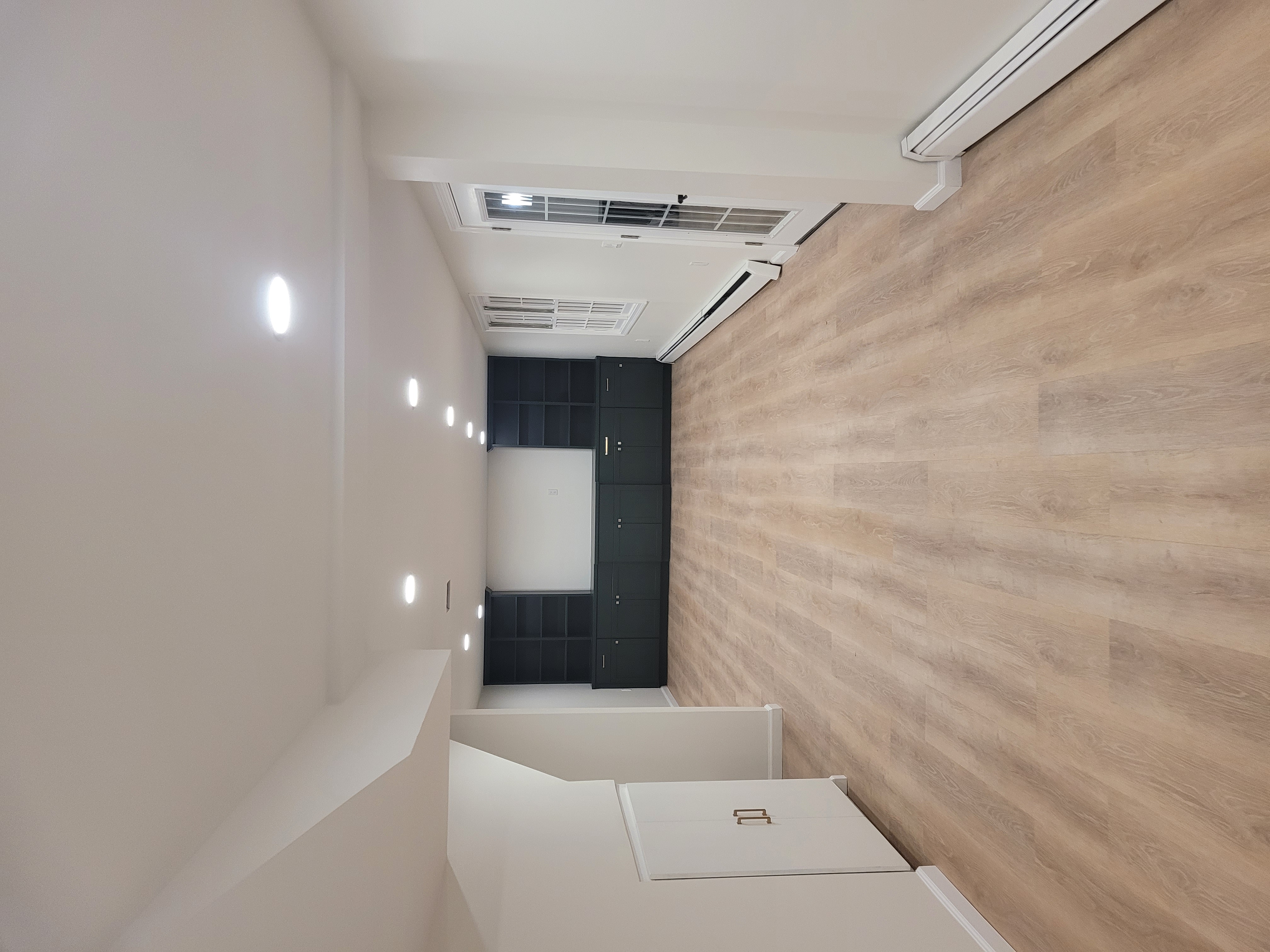 Finished basement viewed toward French doors, a window, and dark built-in cabinetry by Rome Leite Home Improvement in Danbury, CT