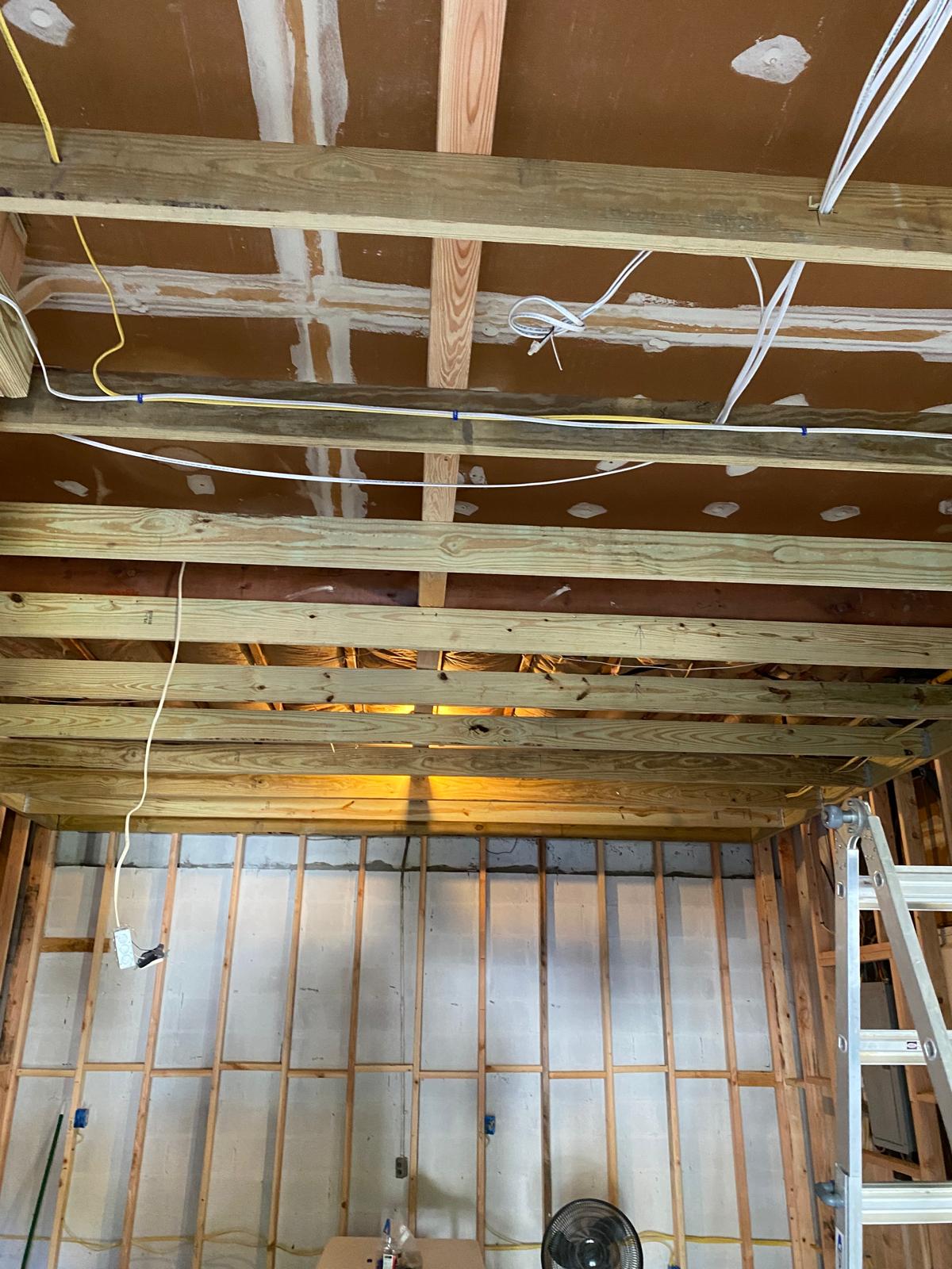 Basement ceiling joists with electrical wiring run between them by Rome Leite Home Improvement in Danbury, CT