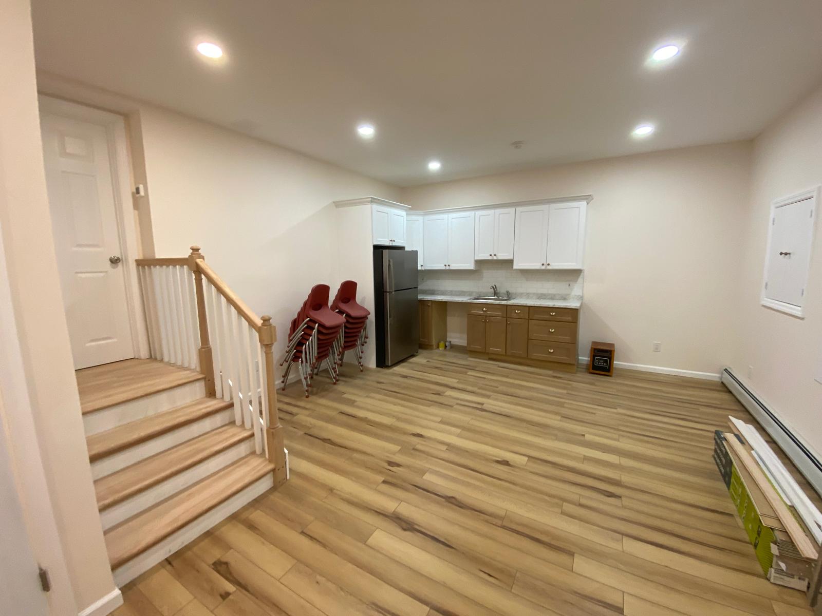 Finished basement room with a small kitchenette and staircase by Rome Leite Home Improvement in Danbury, CT