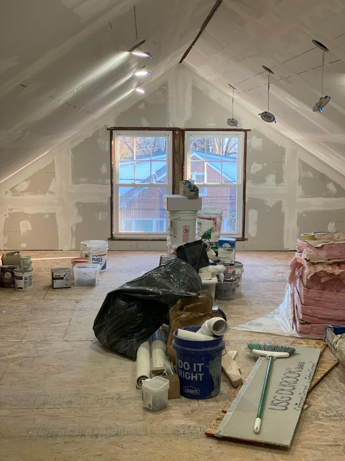 Painted attic room with recessed lighting in the vaulted ceiling, tools staged for finishing work by Rome Leite Home Improvement in Danbury, CT