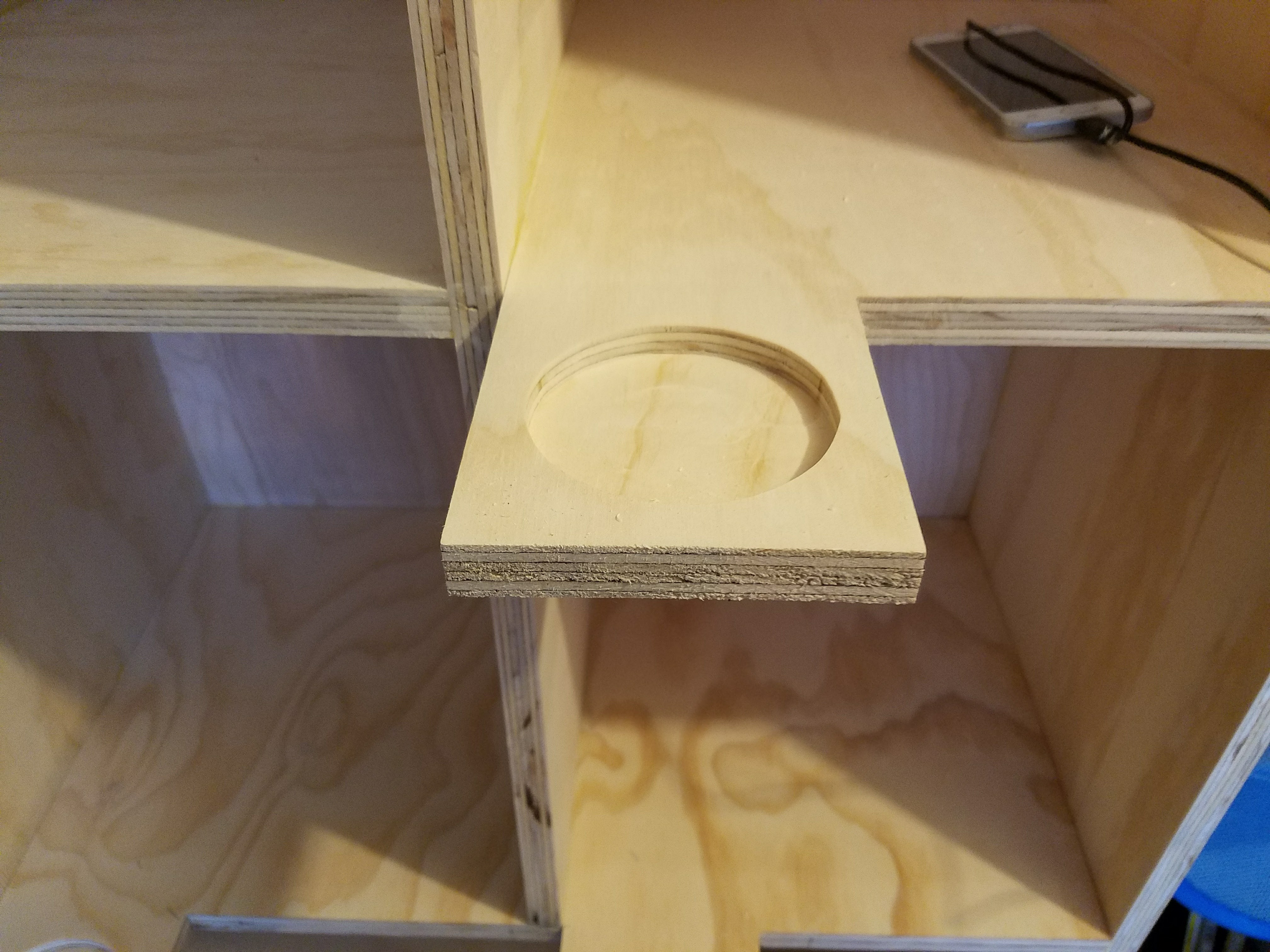 Close-up of a plywood divider panel with a circular cutout during cabinet assembly by Rome Leite Home Improvement in Danbury, CT