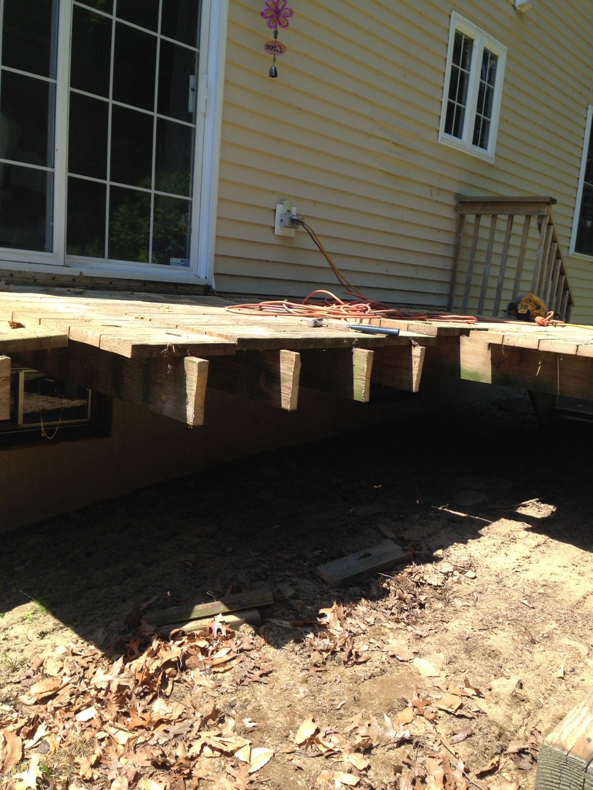 Underside of a deck showing exposed floor joists next to a house by Rome Leite Home Improvement in Danbury, CT