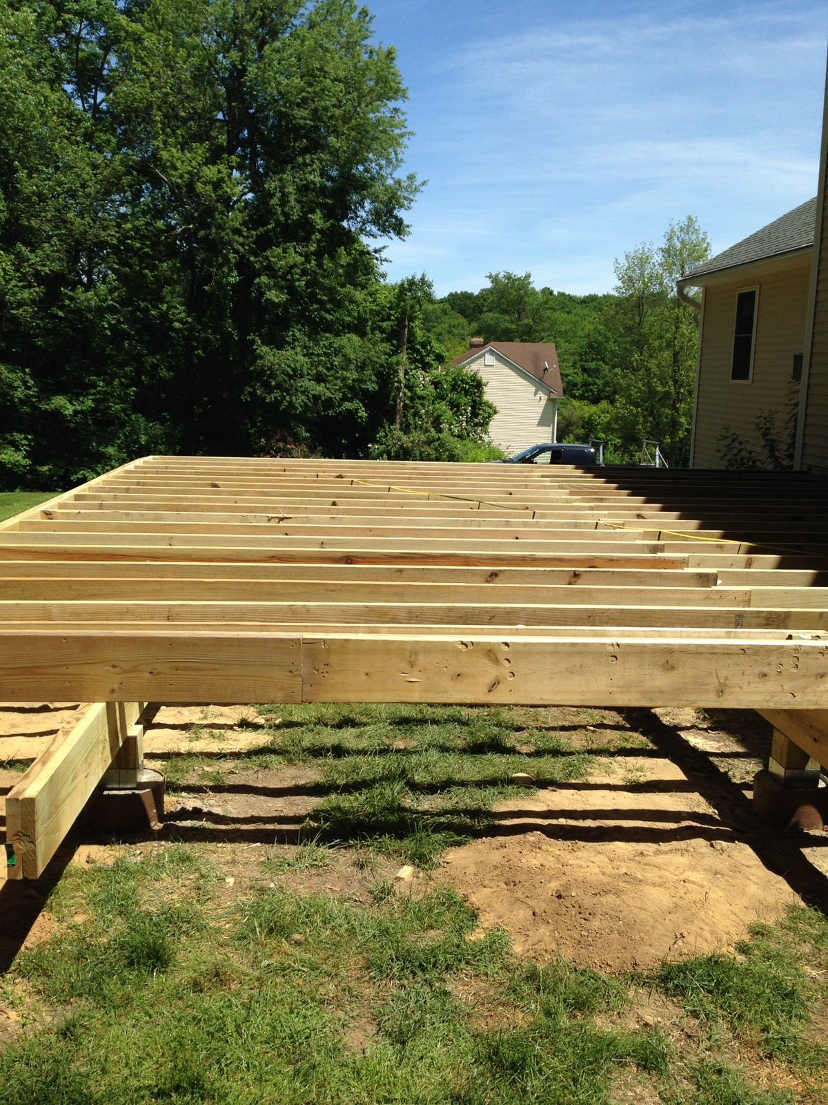 Deck floor joists resting on concrete piers under construction by Rome Leite Home Improvement in Danbury, CT