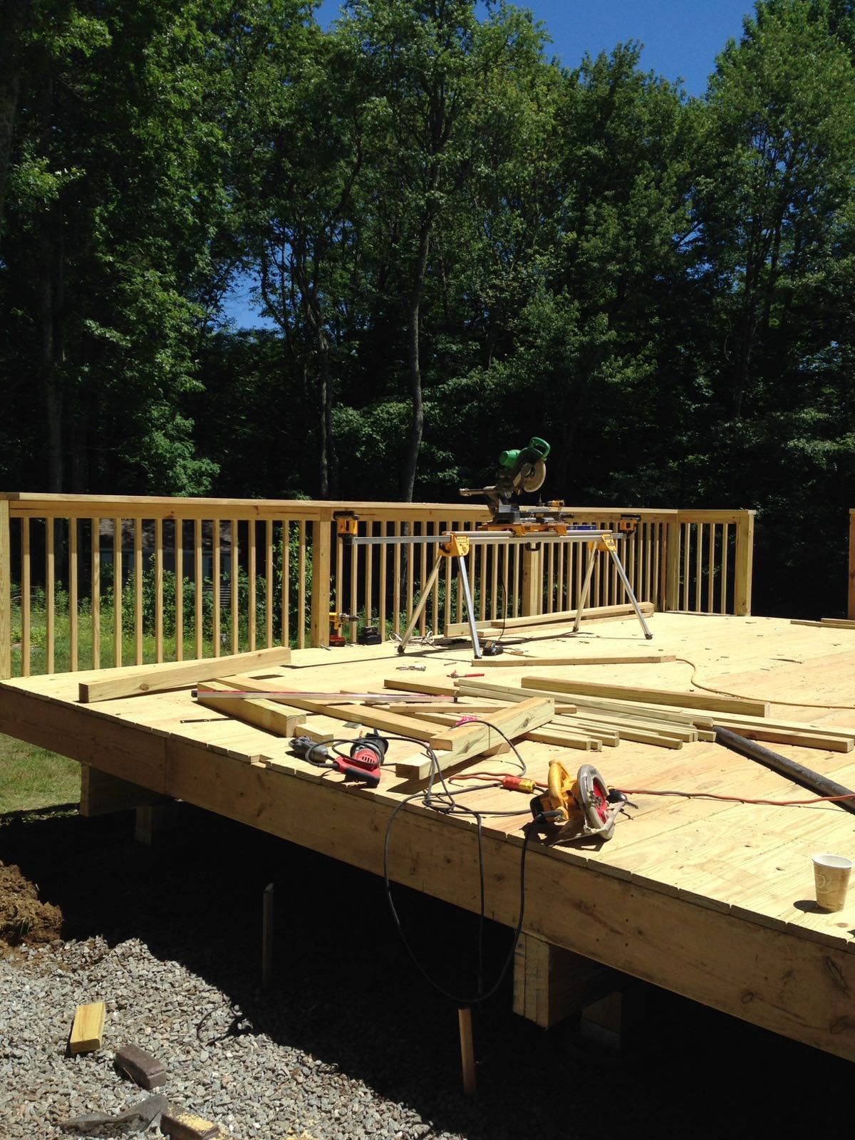 Deck subfloor with power tools near a miter saw station, framed by wood railings by Rome Leite Home Improvement in Danbury, CT