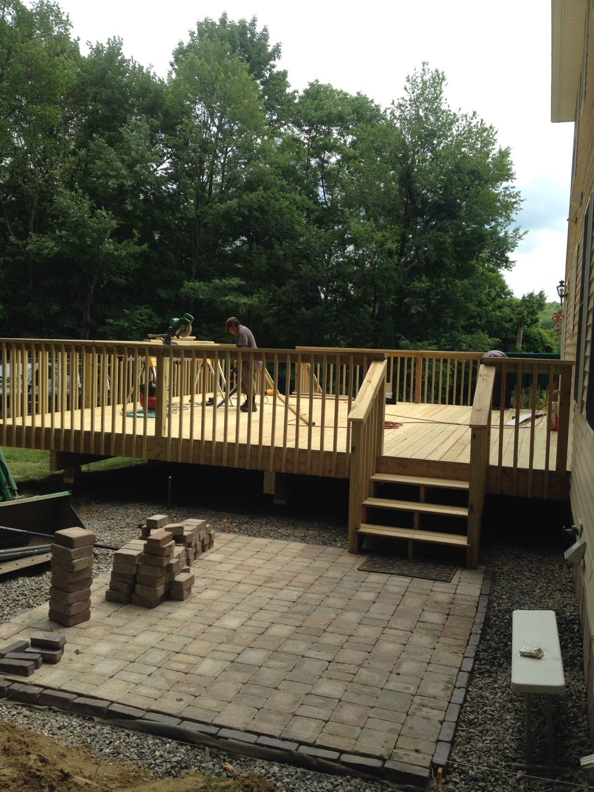 Finished wood deck with stairs leading down to a newly laid paver patio by Rome Leite Home Improvement in Danbury, CT