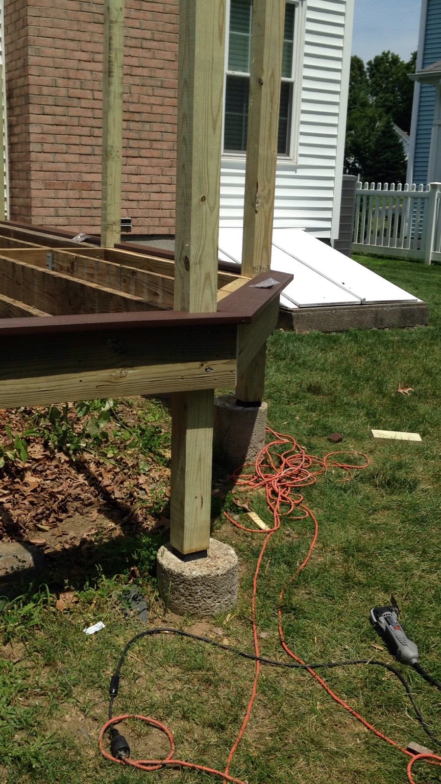 Close-up of a deck corner post with composite decking board installed over the wood frame by Rome Leite Home Improvement in Danbury, CT