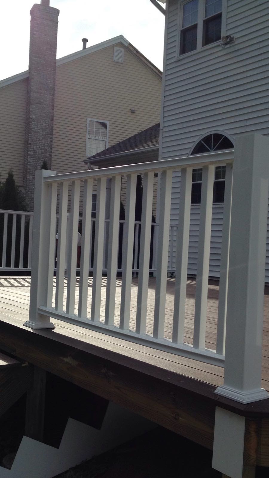 Finished deck with white vinyl railing and dark composite decking by Rome Leite Home Improvement in Danbury, CT