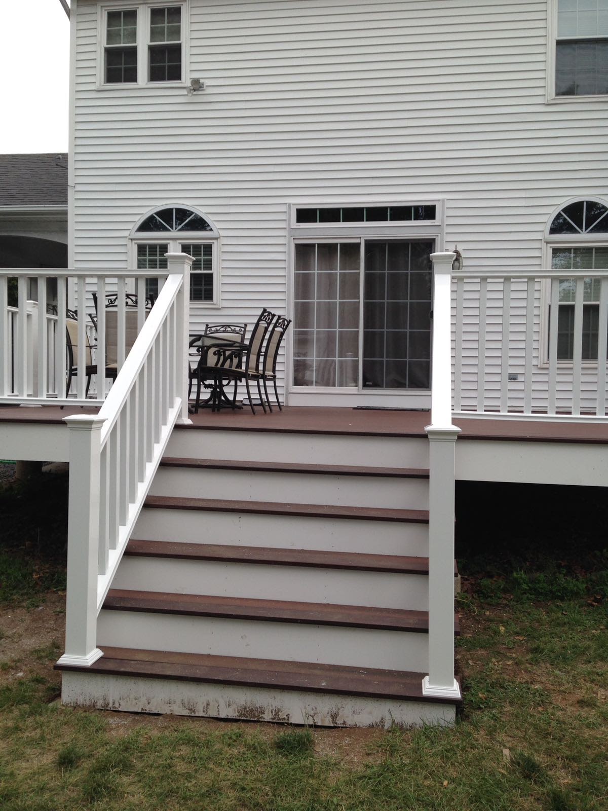 Deck corner with white vinyl railing overlooking a lawn by Rome Leite Home Improvement in Danbury, CT