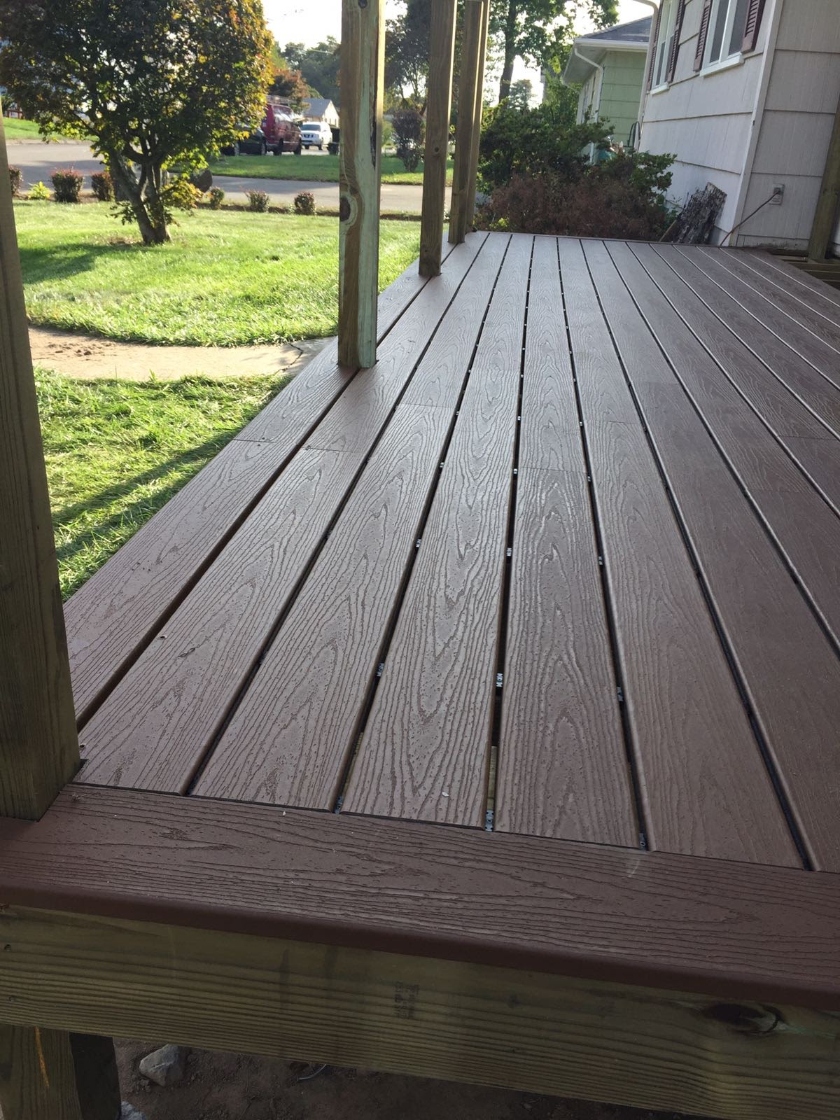New composite deck corner with a view of the front yard and street by Rome Leite Home Improvement in Danbury, CT