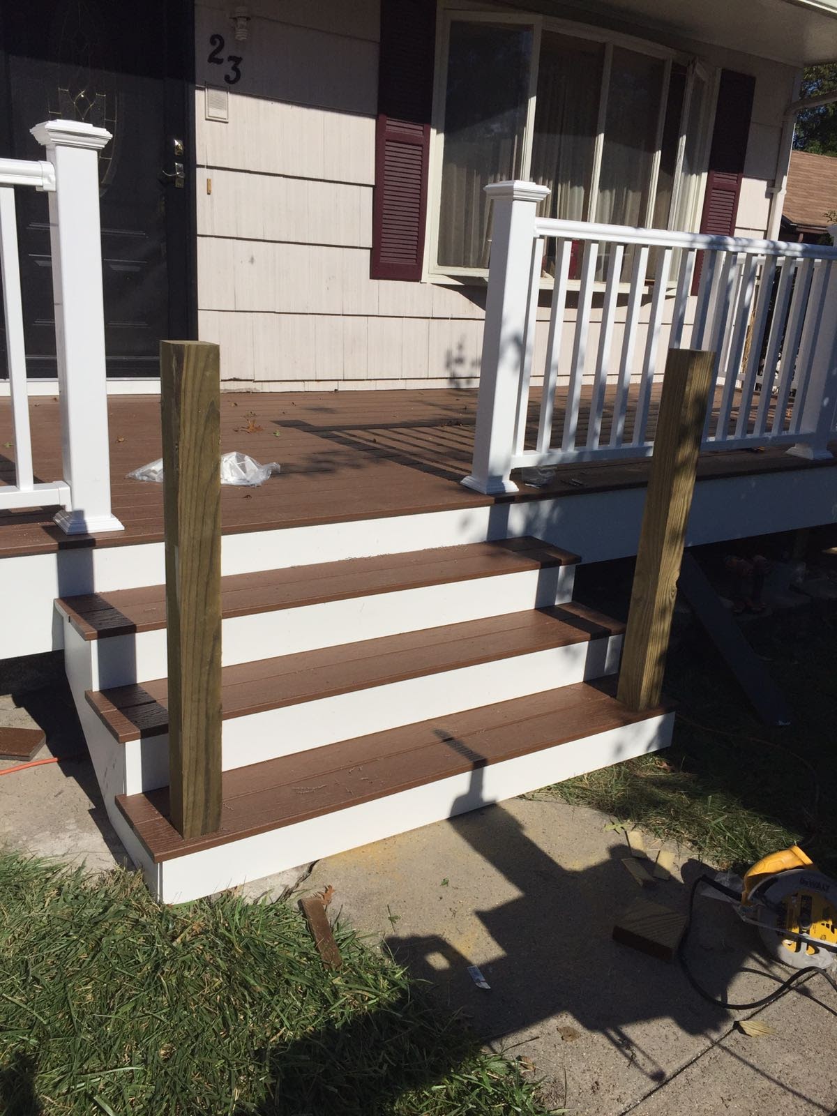 New composite deck steps with white risers and vinyl railings being installed by Rome Leite Home Improvement in Danbury, CT
