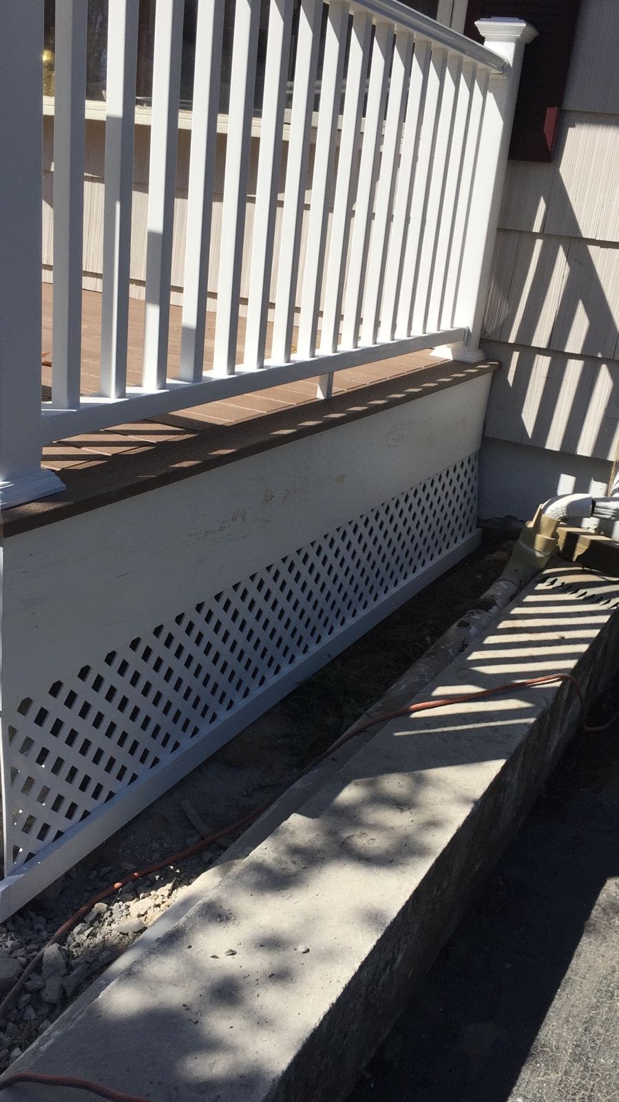 White vinyl lattice skirting installed under the edge of a composite deck by Rome Leite Home Improvement in Danbury, CT