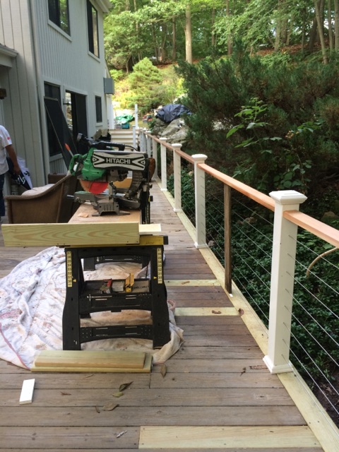 Deck under construction with a cable railing system and a miter saw station by Rome Leite Home Improvement in Danbury, CT