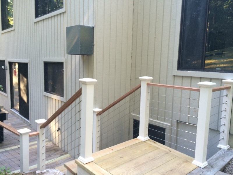 Close-up of a deck stair railing post and a utility box mounted on the house siding by Rome Leite Home Improvement in Danbury, CT