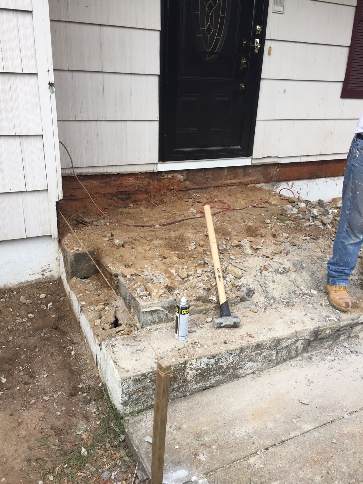 Close-up of rotted wood band board exposed above a foundation near a front door by Rome Leite Home Improvement in Danbury, CT