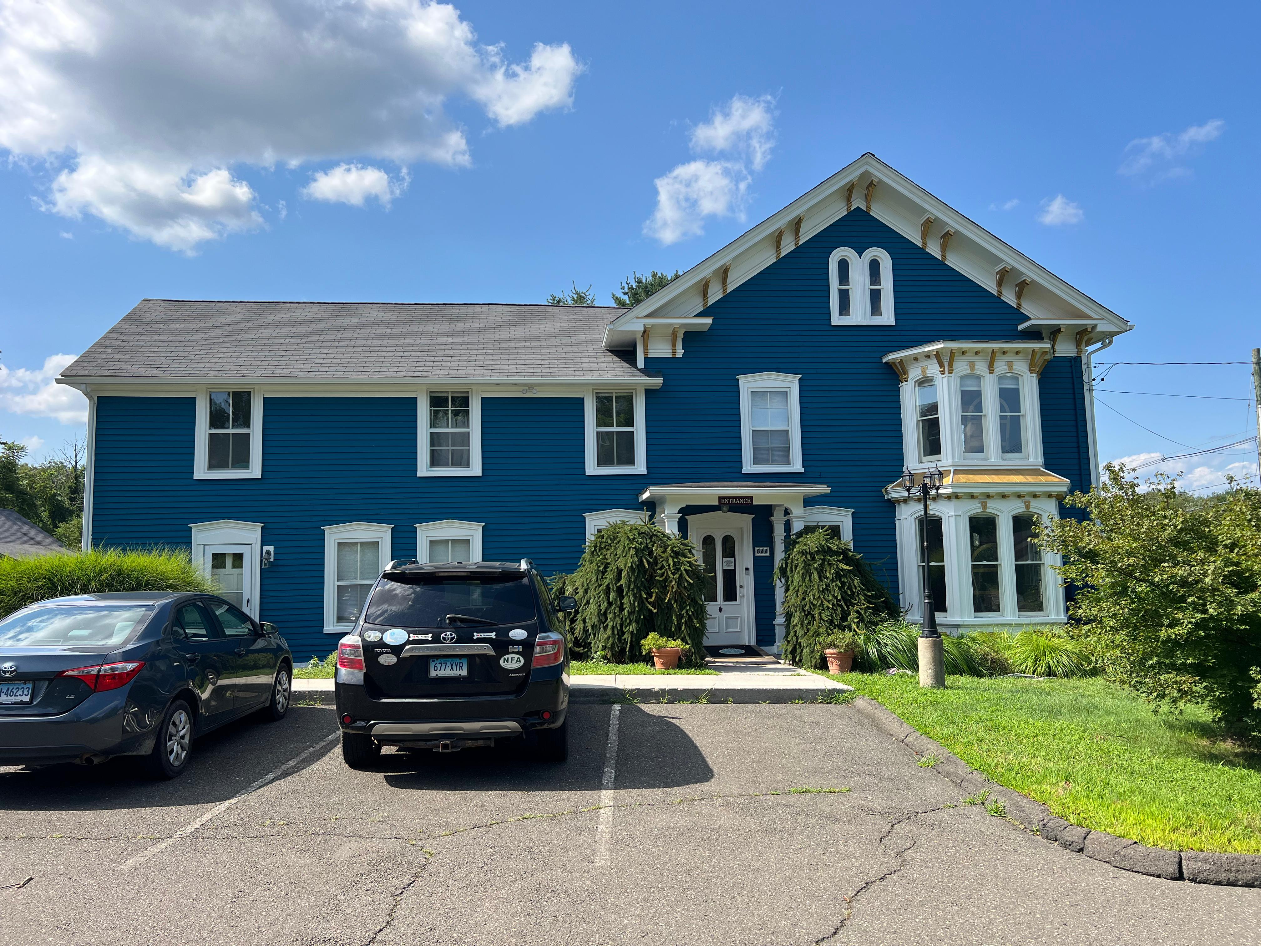 Exterior of a two-story blue Victorian house with white trim, freshly painted by Rome Leite Home Improvement in Danbury, CT