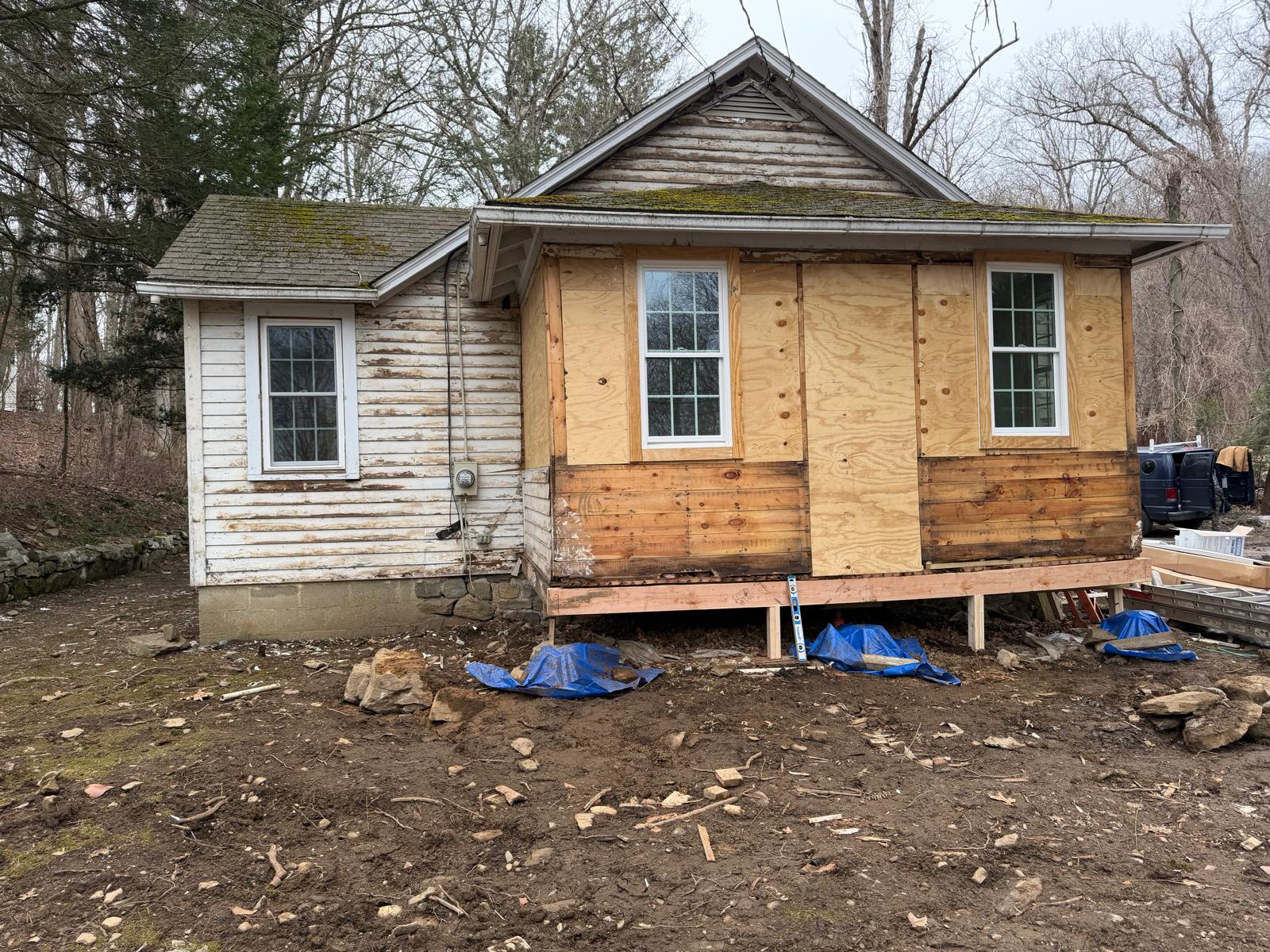 Exterior of an older house before renovation, showing peeling painted wood siding by Rome Leite Home Improvement in Danbury, CT