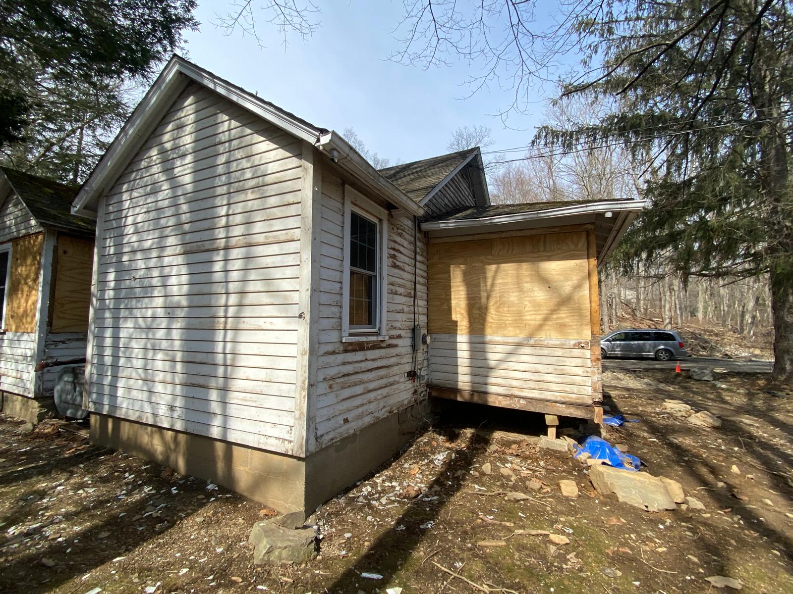 Exterior of a house addition sheathed in plywood with two windows by Rome Leite Home Improvement in Danbury, CT