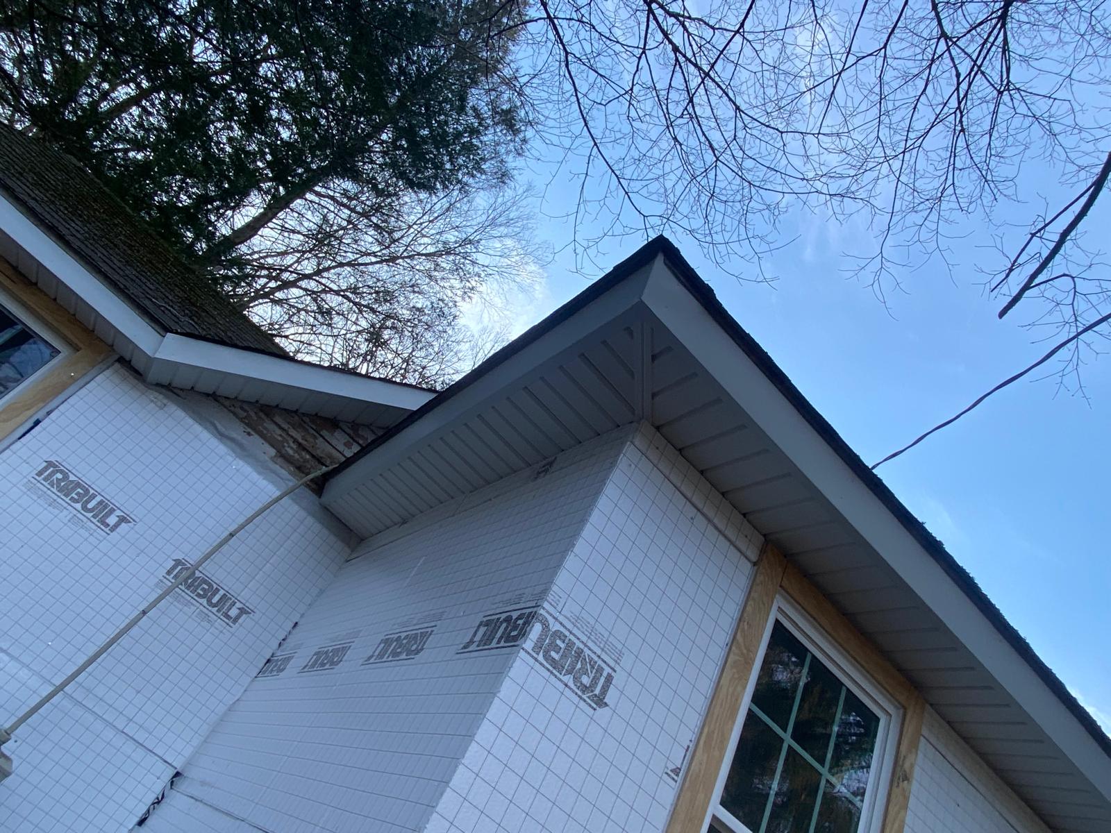 Close-up looking up at a roof eave and soffit, with house wrap on the walls below by Rome Leite Home Improvement in Danbury, CT