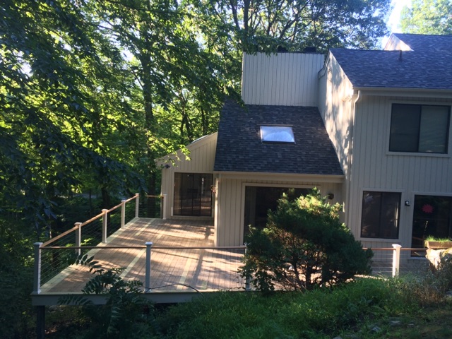 Exterior of a house showing a skylight in the roof and a deck with cable railing by Rome Leite Home Improvement in Danbury, CT