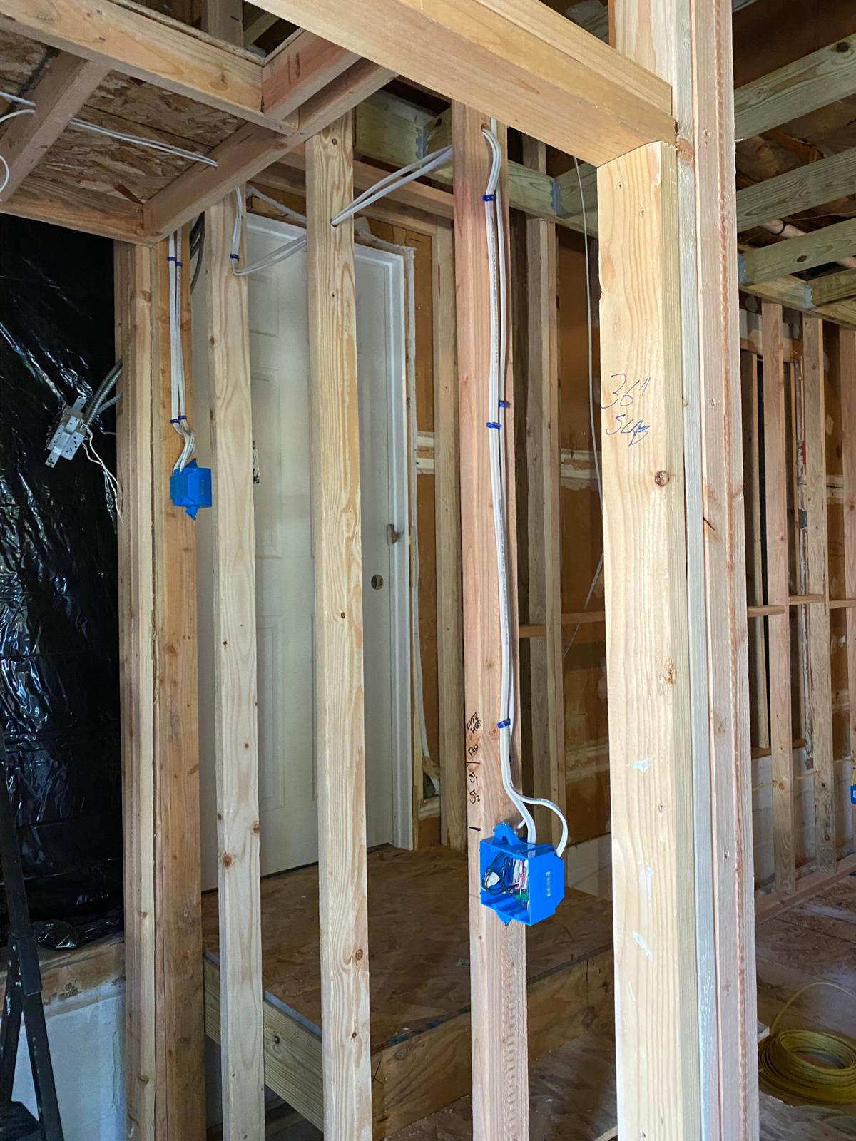 Exposed ceiling joists and stud wall framing with electrical wiring by Rome Leite Home Improvement in Danbury, CT