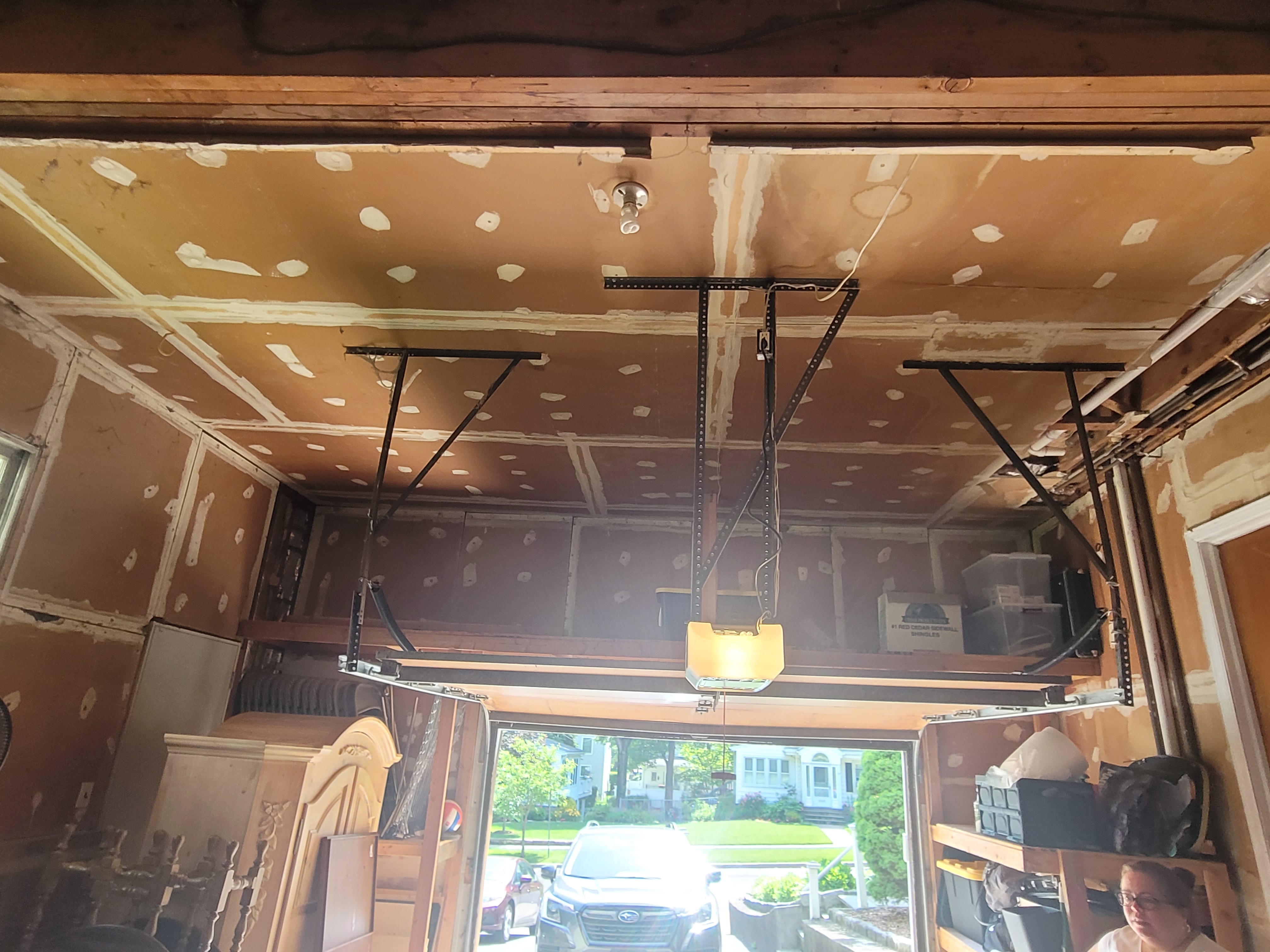 Unfinished garage ceiling with taped drywall seams and a garage door opener installed by Rome Leite Home Improvement in Danbury, CT