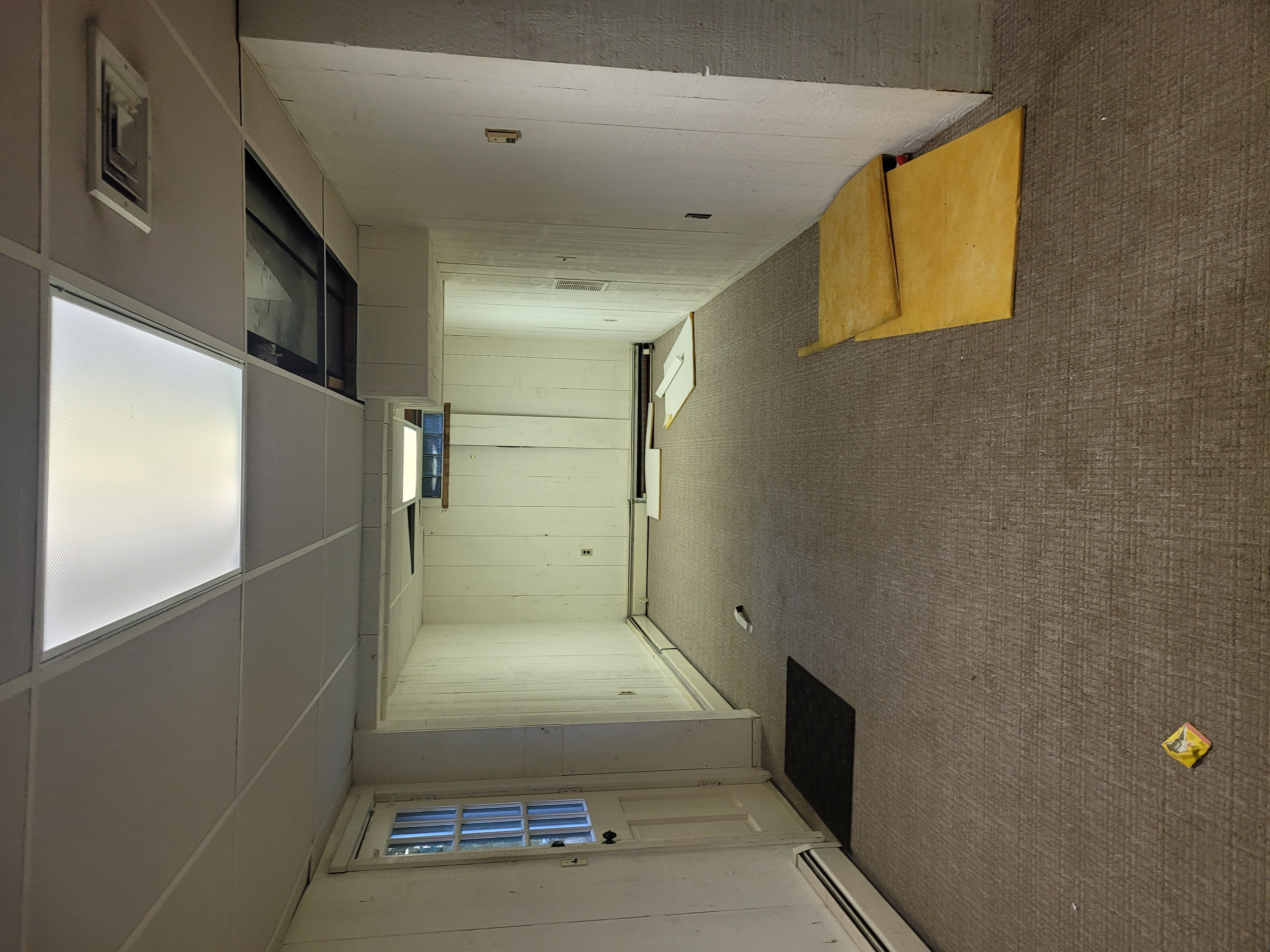 Hallway area with plywood panels staged for installation near dark cabinetry by Rome Leite Home Improvement in Danbury, CT