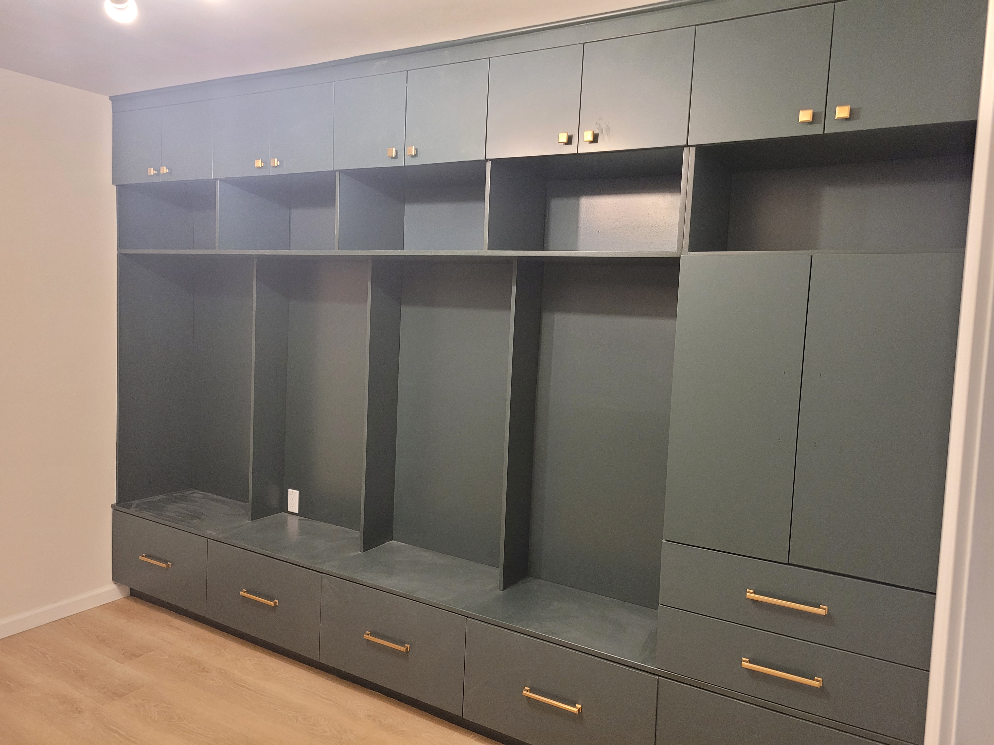 Empty mudroom-style built-in lockers and cubbies with brass hardware by Rome Leite Home Improvement in Danbury, CT