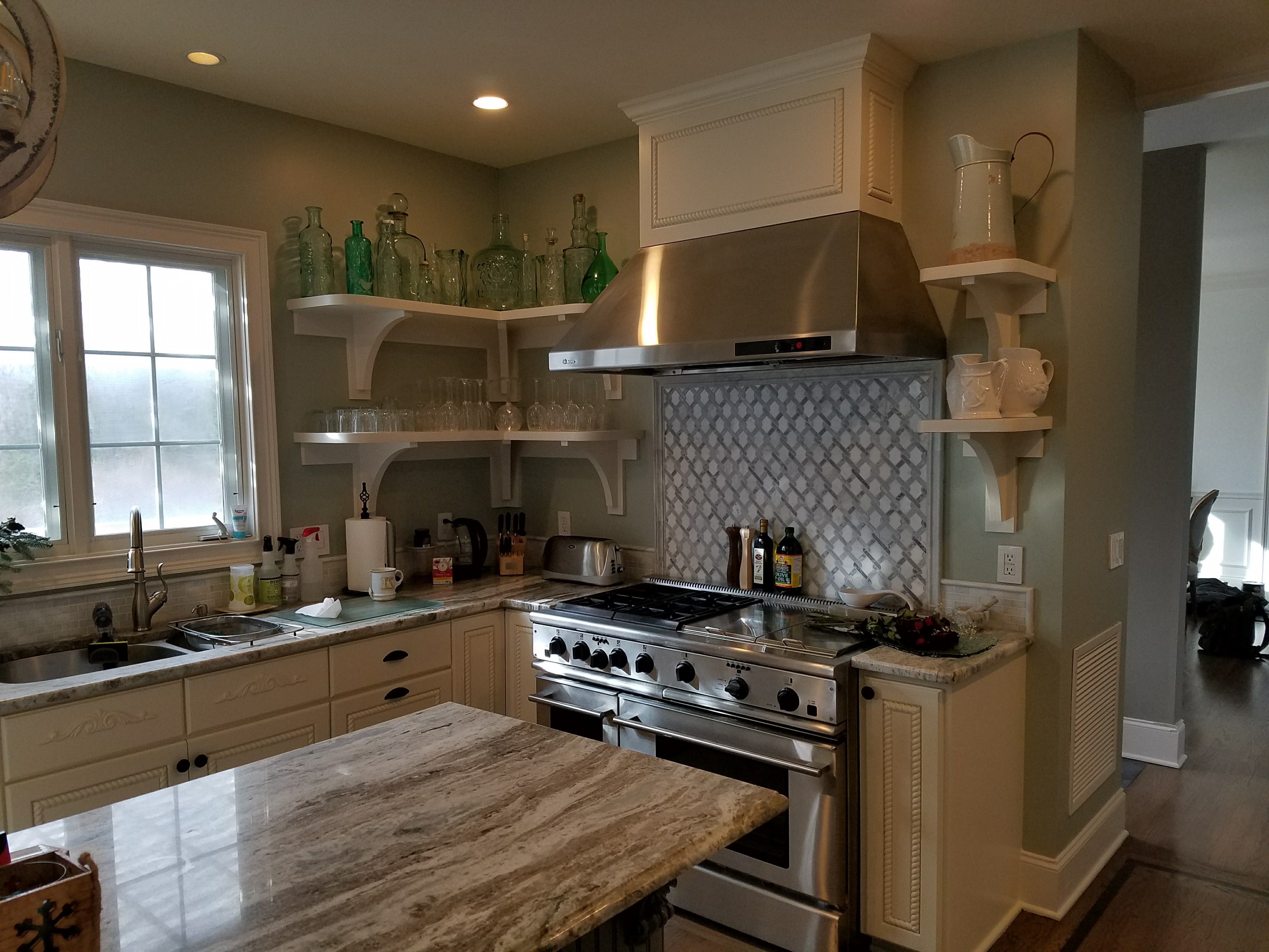 Close view of a finished kitchen's range, stainless hood, and mosaic tile backsplash by Rome Leite Home Improvement in Danbury, CT