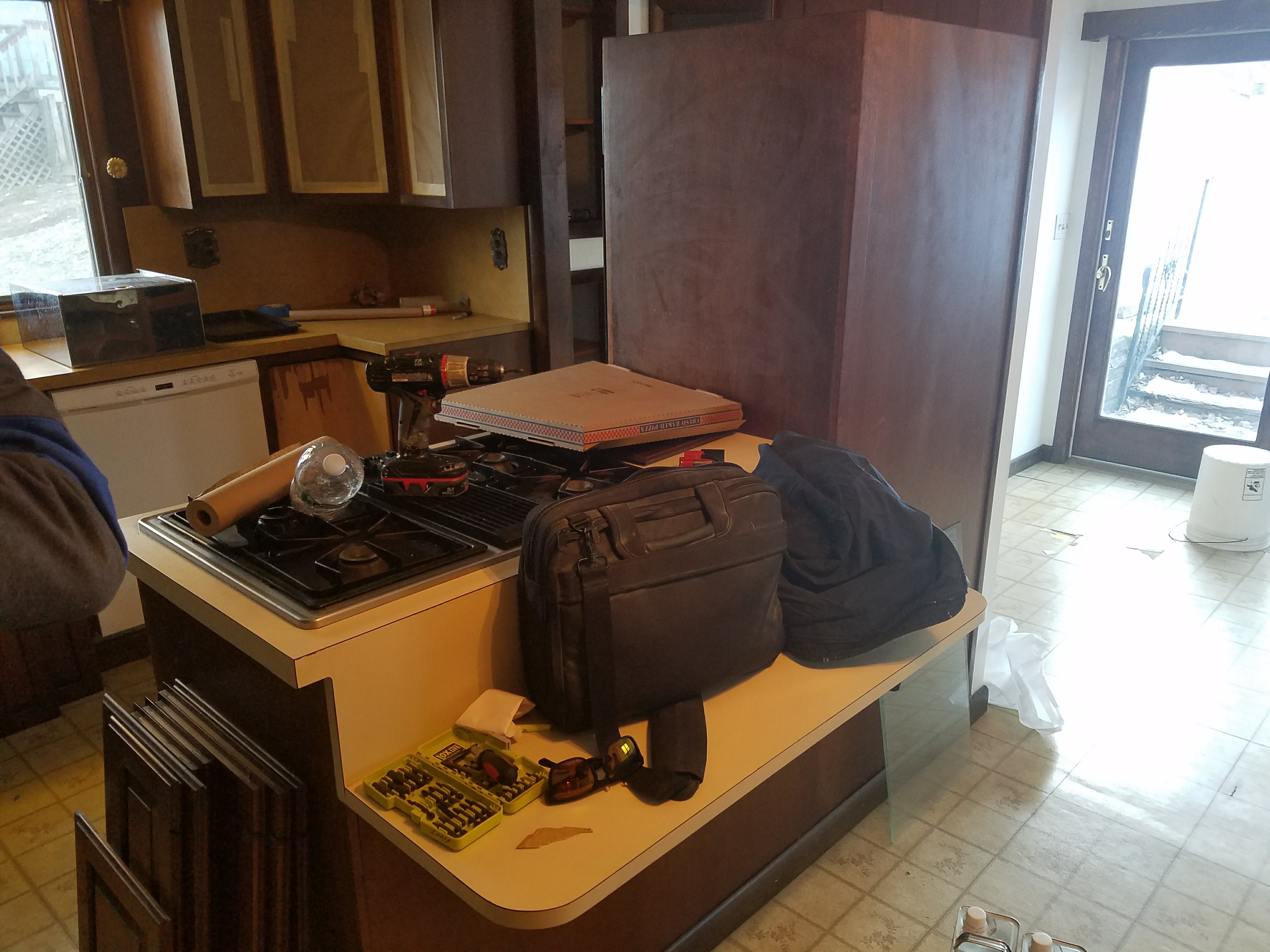 Kitchen renovation in progress with dark wood cabinets and tools by Rome Leite Home Improvement in Danbury, CT